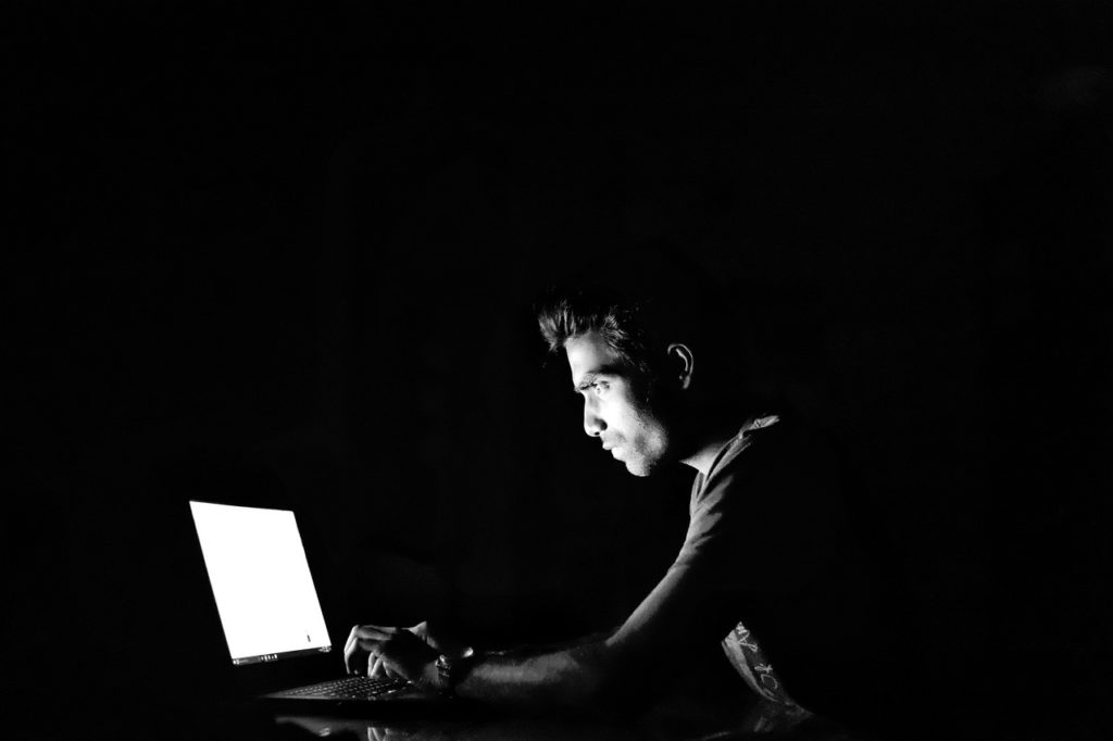 man working on computer in the dark