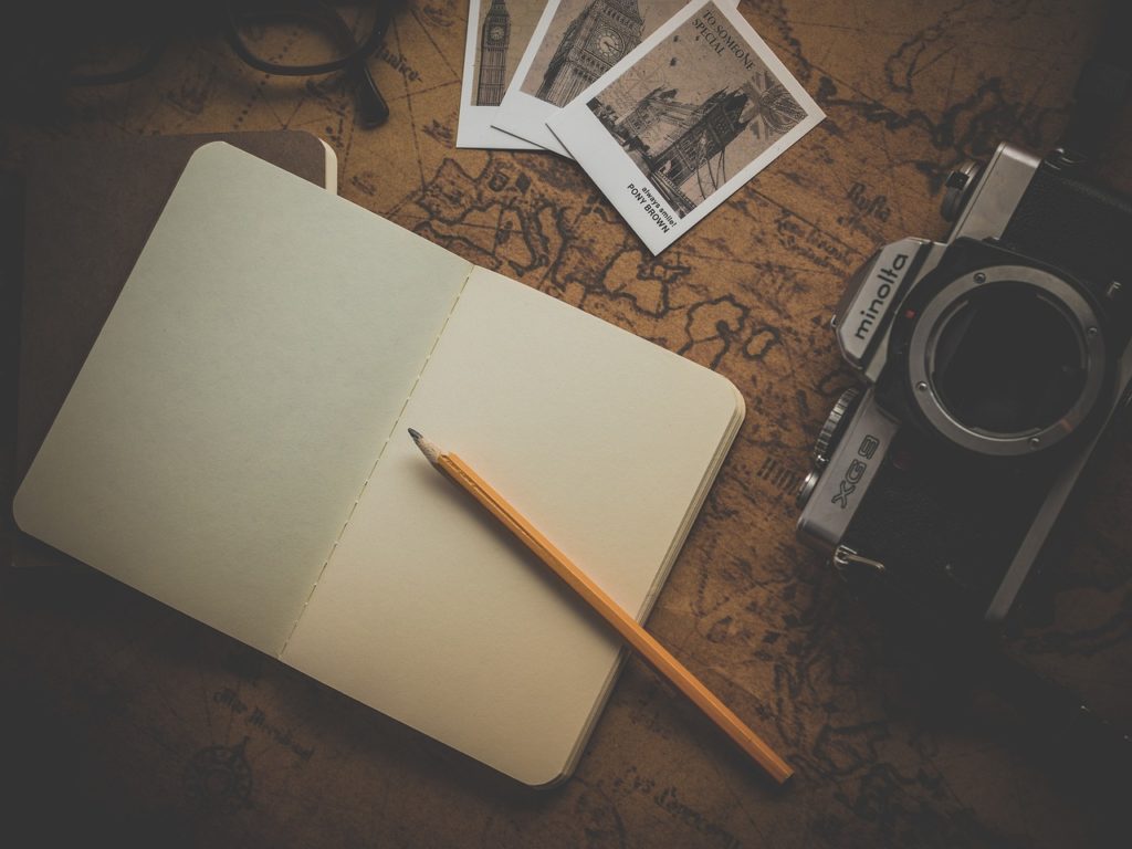 planning travel with camera journal and pictures